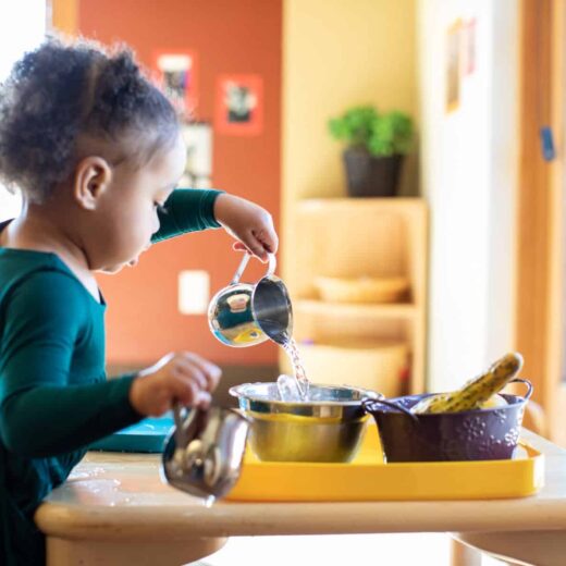 child pouring water into bowl