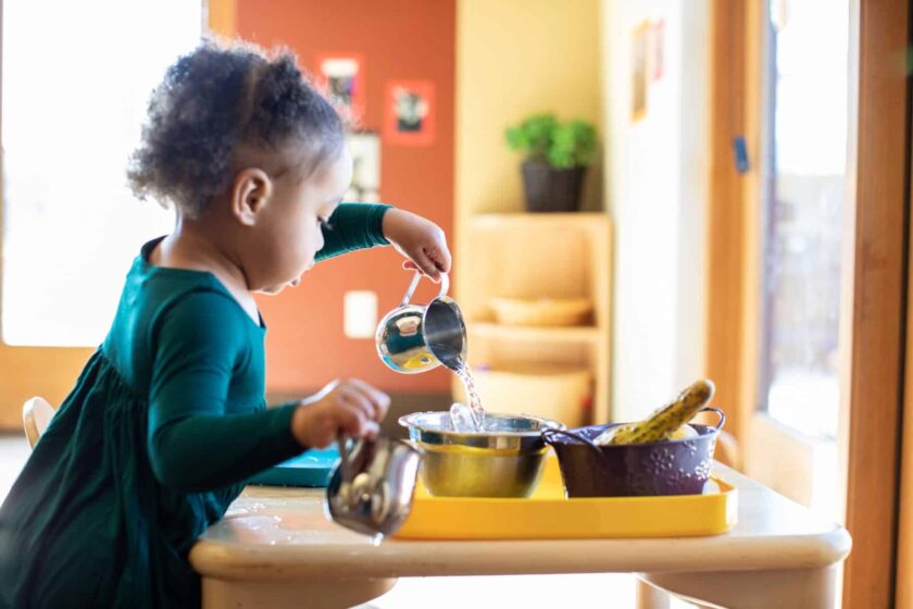 child pouring water into bowl
