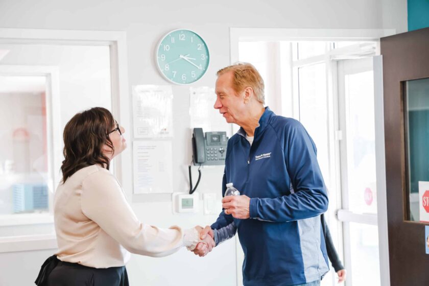 two people shaking hands in a greeting.