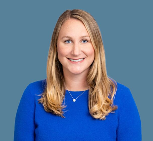 Headshot of a blonde woman in blue shirt smiling.
