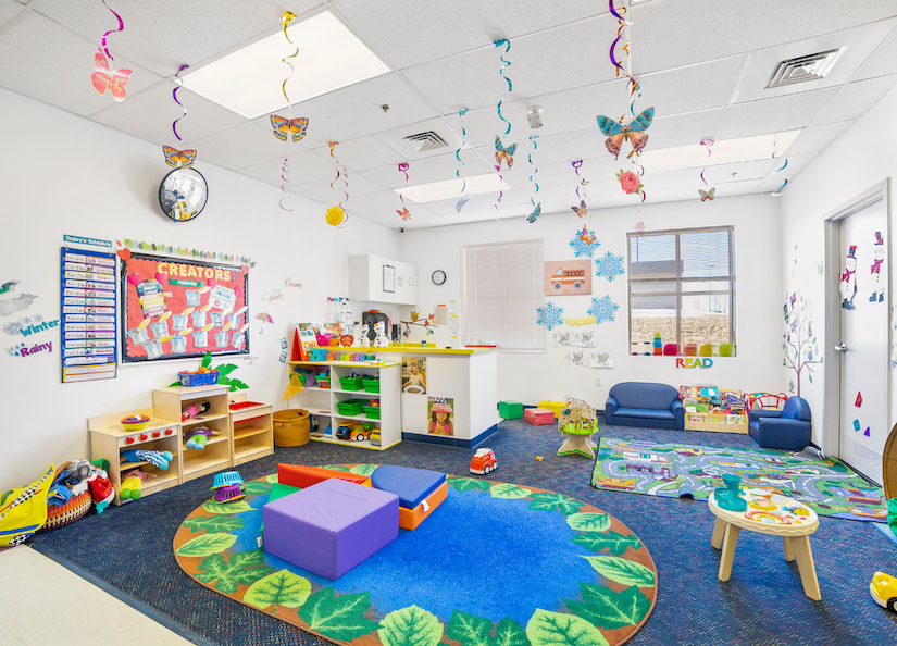 Child's classroom with colorful toys and rugs.